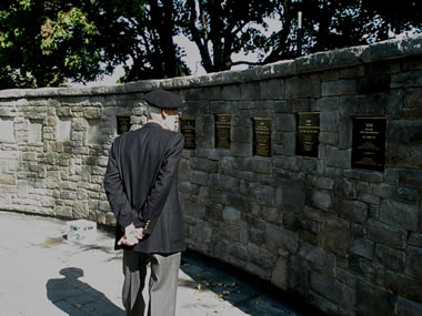 Old Brigade Ex-Cadet reading bronze plaques on Wall